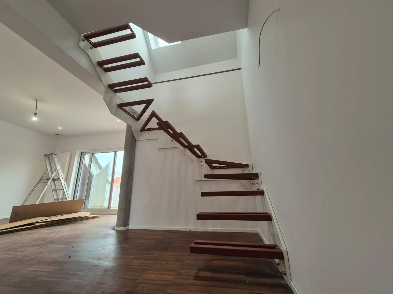 Escalier crémaillère en acier laqué blanc avec marches bois massif sous verrière, escalier design