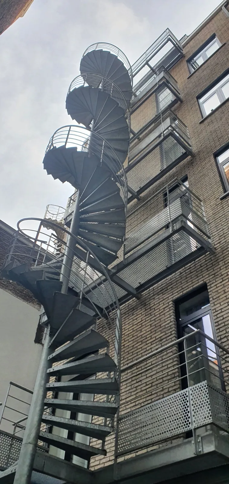 Escalier de secours hélicoïdal en acier galvanisé sur plusieurs niveaux, sécurité incendie sur mesure